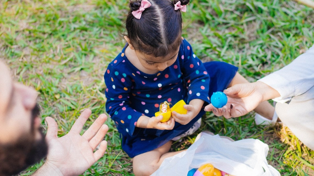 a little girl sitting on the ground playing with a toy