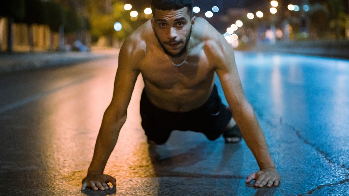 topless man in black shorts kneeling on floor
